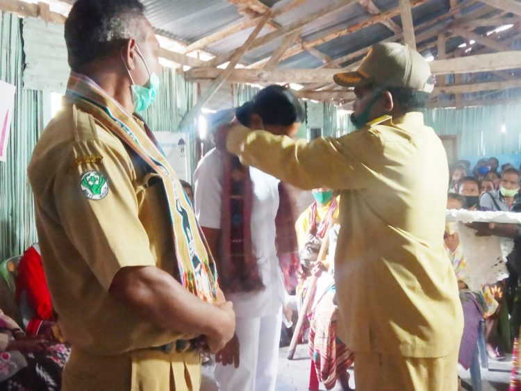 Kepala Desa Mnela'anen, Justus A Fallo saat mengalungkan selendang kepada perawat yang akan bertugas di Desa Mnela'anen ( Foto: Joe Kikhau/BentaraNet)