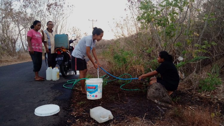 Warga dari Desa Lewotobi mengambil air dari pipa bocor yang melewati wilayah tersebut / Foto :Bentara.net (Redem Welan)
