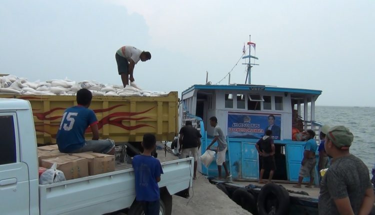 Relawan menurunkan bantuan anggota DPR RI, Ahmad Yohan berupa beras, minyak goreng, mie instan dan alat rapid test dari kapal pengangkut di Pelabuhan Laut Lewoleba, Sabtu (5/12/2020) / Foto : BentaraNet