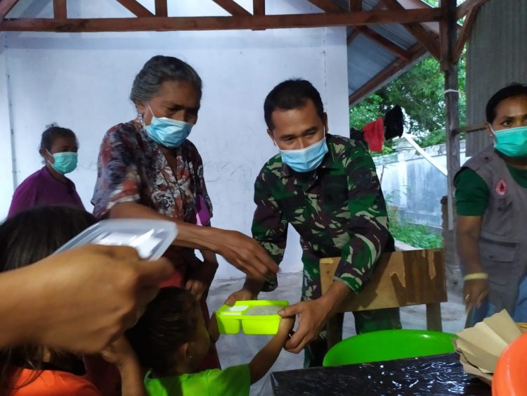 Seorang anggota TNI melayani makan anak-anak di posko pengungsian erupsi Gunung Api Ile Lewotolok, di halaman eks Kantor Bupati Lembata, Lewoleba, Senin (7/12/2020) / Foto : BentaraNet