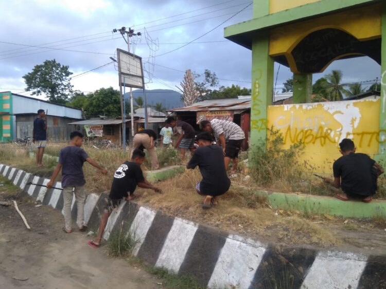 Anak-muda yang tergabung dalam organisasi IKA Wanted membersihkan area tugu selamat datang di Simpang Lima Wangatoa pada Sabtu (12/6) / Foto : Istimewa