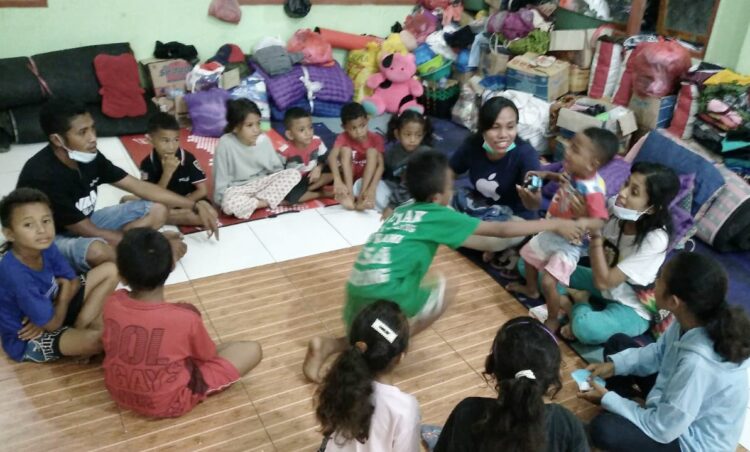 Anak-anak yang berada di posko pengungsian kantor Lurah Lewoleba Timur, Kabupaten Lembata bermain bersama relawan dari Anggota AMA Lembata pada Rabu (16/6) malam. Kunjungan AMA Lembata ke posko pengungsian ini untuk menghibur para penyintas banjir bandang dan longsor di Kabupaten Lembata / Sumber Foto : AMA Lembata