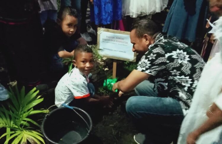 Pastor Paroki Kristus Raja Wangatoa, RD Kristo Soge bersama anak-anak SEKAMI dan umat Lingkungan Katolik Lingkungan Santo Kornelius Komak menanam pohon saat perayaan Natal dan Tahun Baru bersama / Foto : Istimewa